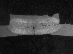 Closeup photo of Nugget showing a surface crack and holes in the center of the weld. Holes at the edge of the interface were caused by interfacial expulsion.